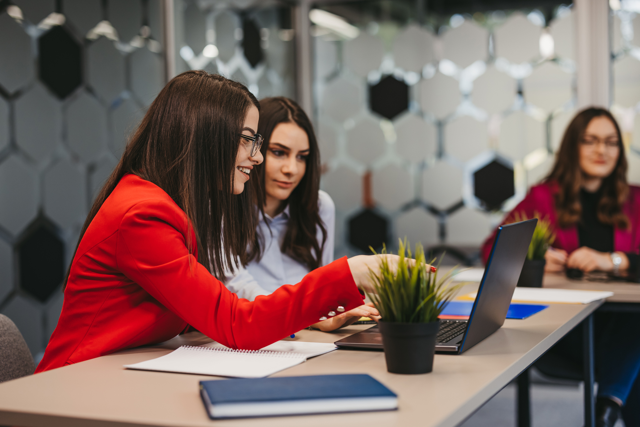 Businesswomen having a discussion whilst looking at laptop during a meeting in the office.