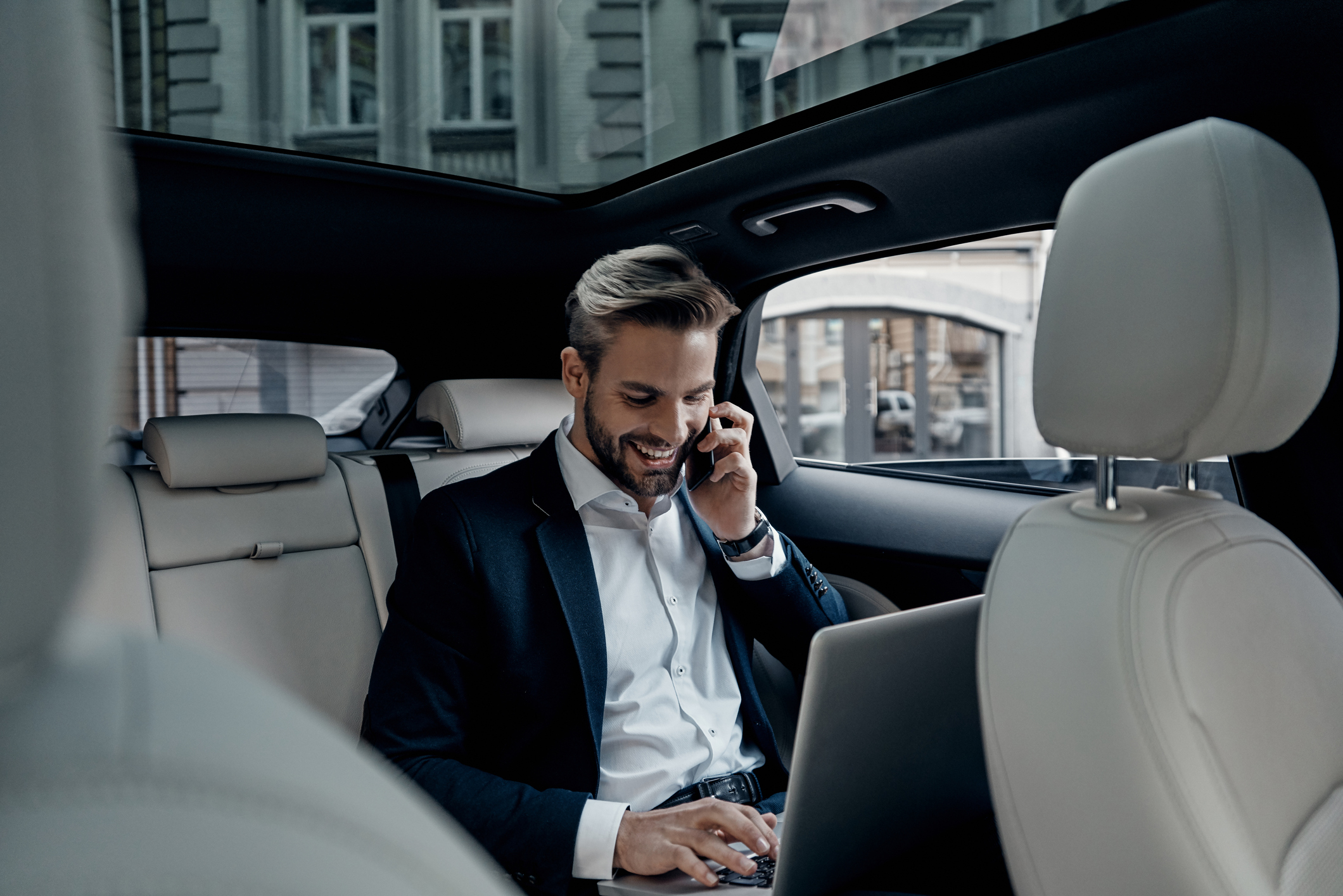 Man talking on the phone whilst working from his car