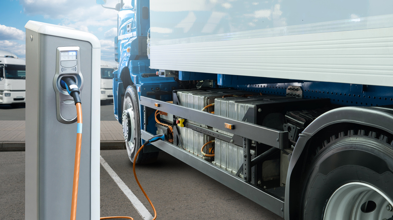 Electric truck plugged in at charging station