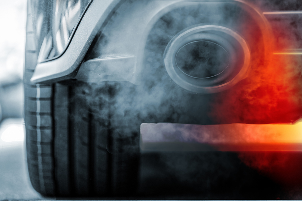 Close-up shot showing emission from exhaust pipe of SUV car